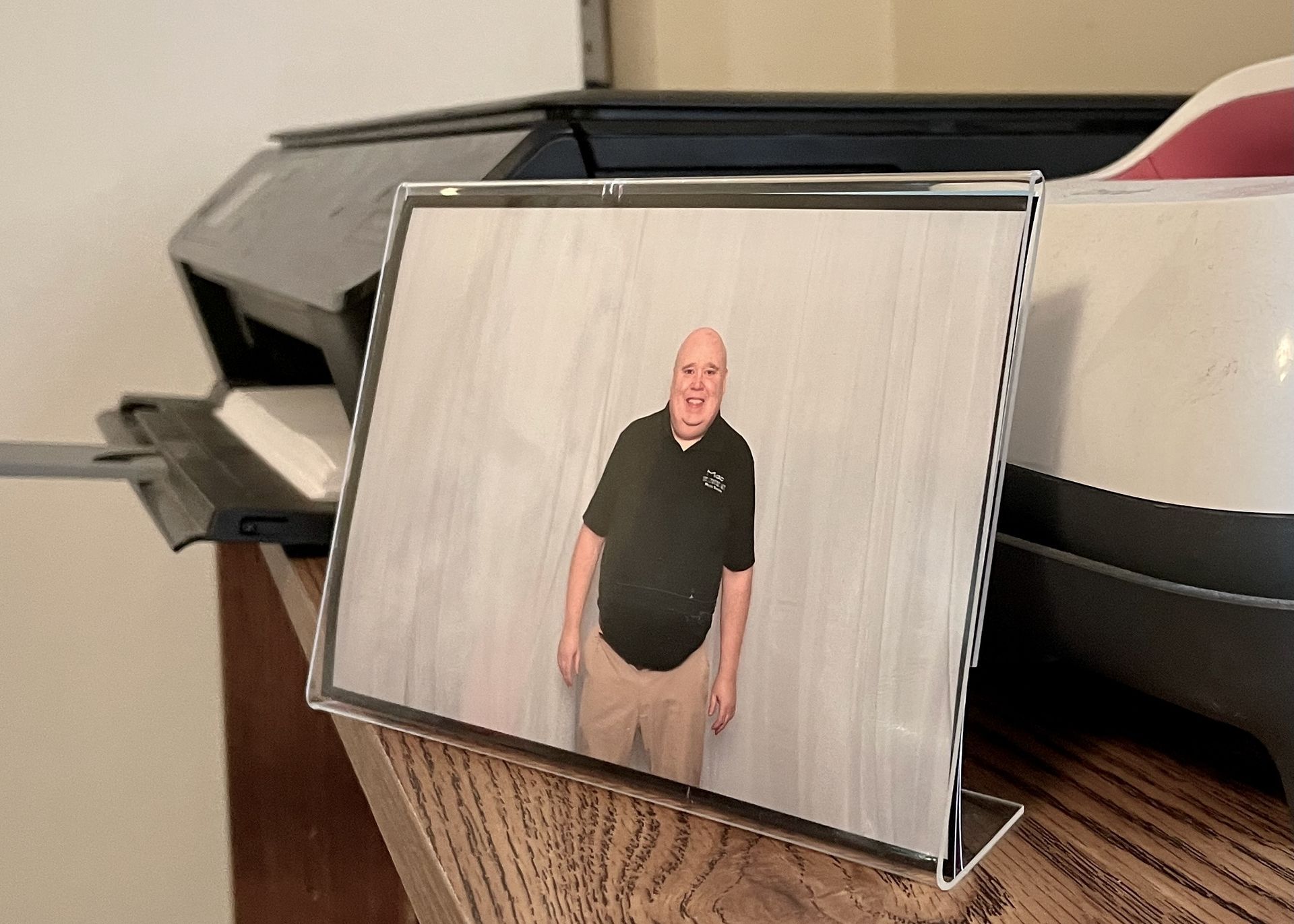 Acrylic Photo Frame A picture of a man standing next to a printer on a table.