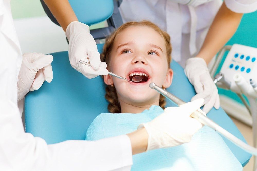 Girl in Dentist Chair, Mouth Open, Receiving Dental Checkup — Tamworth Orthocare In Armidale, NSW
