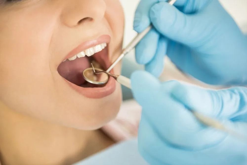 Dentist Examining Patient's Teeth With Tools; Hands in Blue Gloves — Tamworth Orthocare In Armidale, NSW