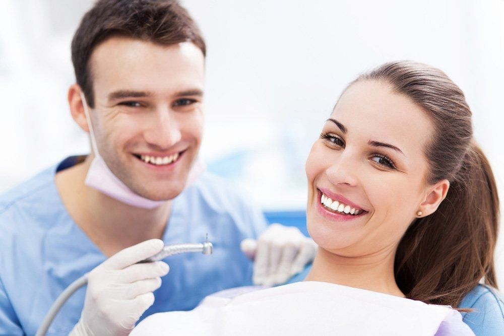 Dentist and Patient Smiling in Dental Office; Dentist Holding Tool — Tamworth Orthocare In Narrabri, NSW