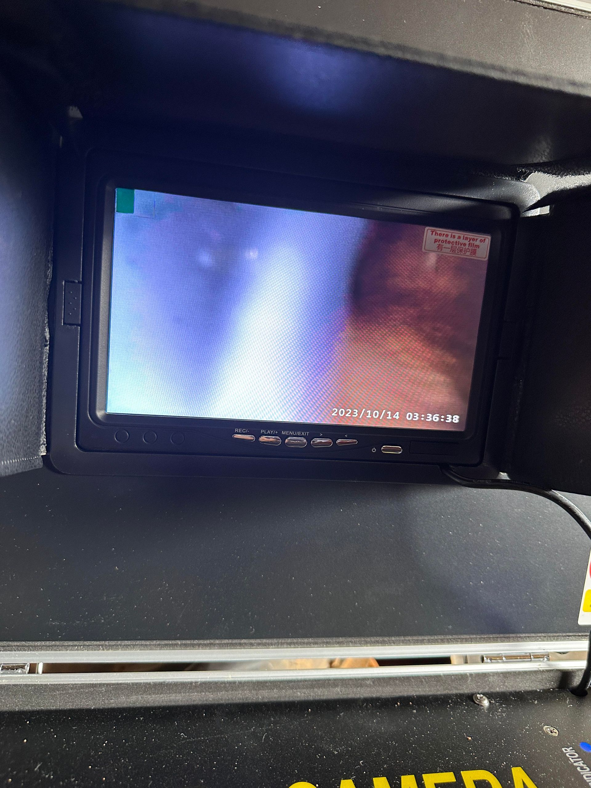 A digital monitor showing a close-up, dimly lit view of an internal passage, likely from an inspection camera.