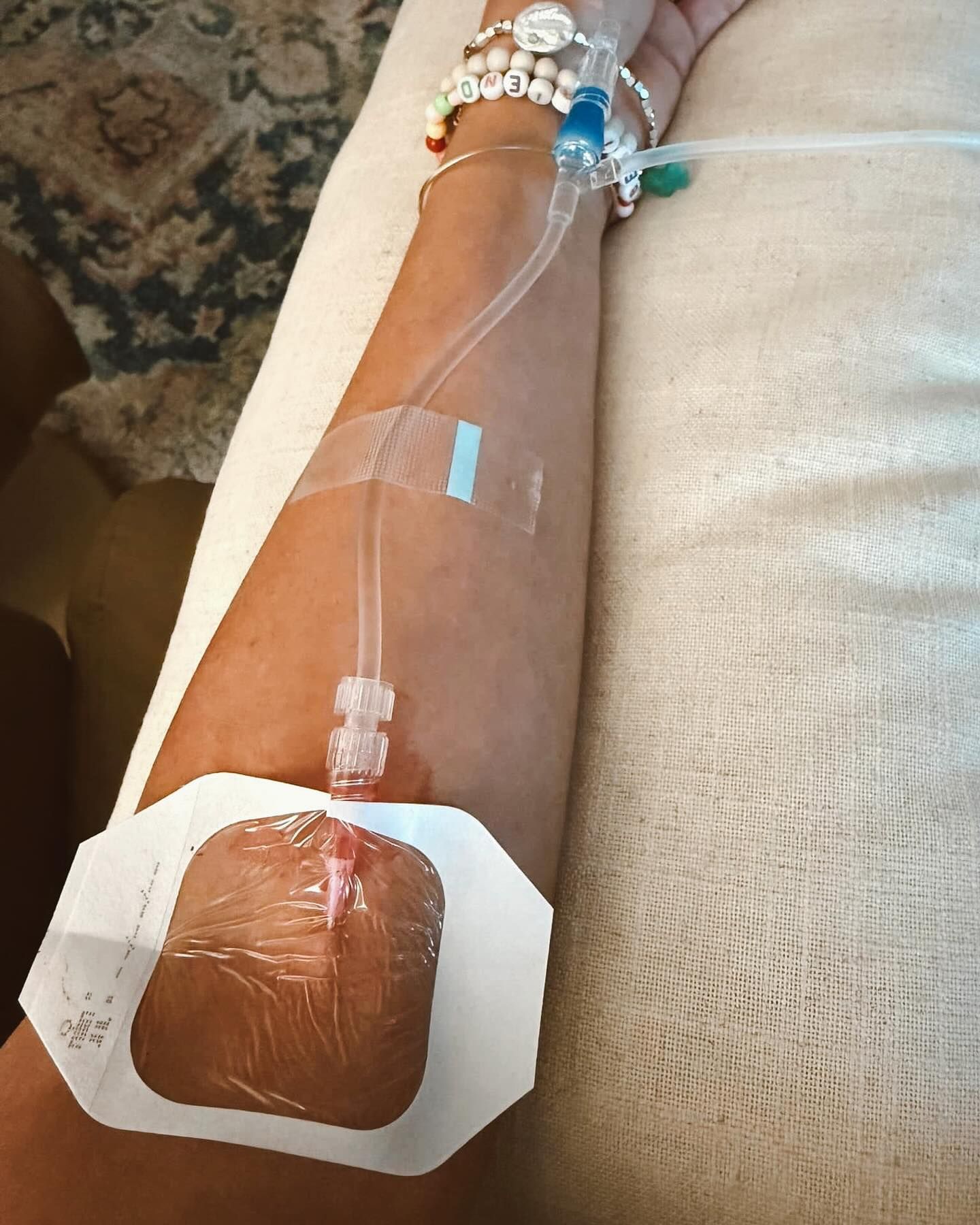 IV line on arm with clear tubing and adhesive dressing over a hand or wrist