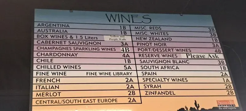 Blue wine menu board listing red, white, rosé, champagne, and specialty wines by region and price.
