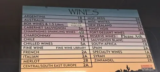 Handwritten wine menu on paper, with categories and prices listed in columns.