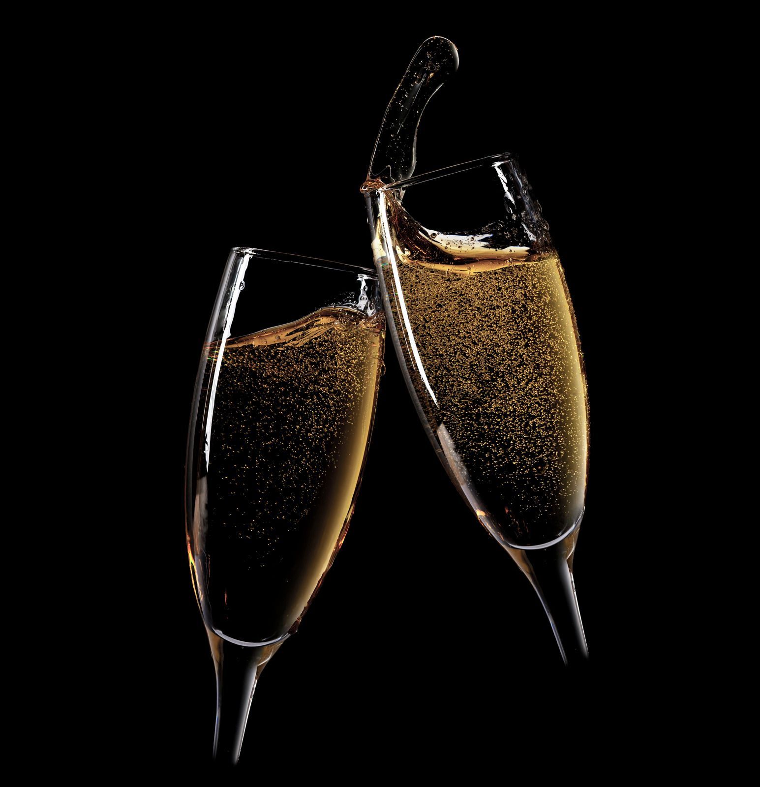 Two champagne flutes clinking, filled with sparkling golden wine on a black background