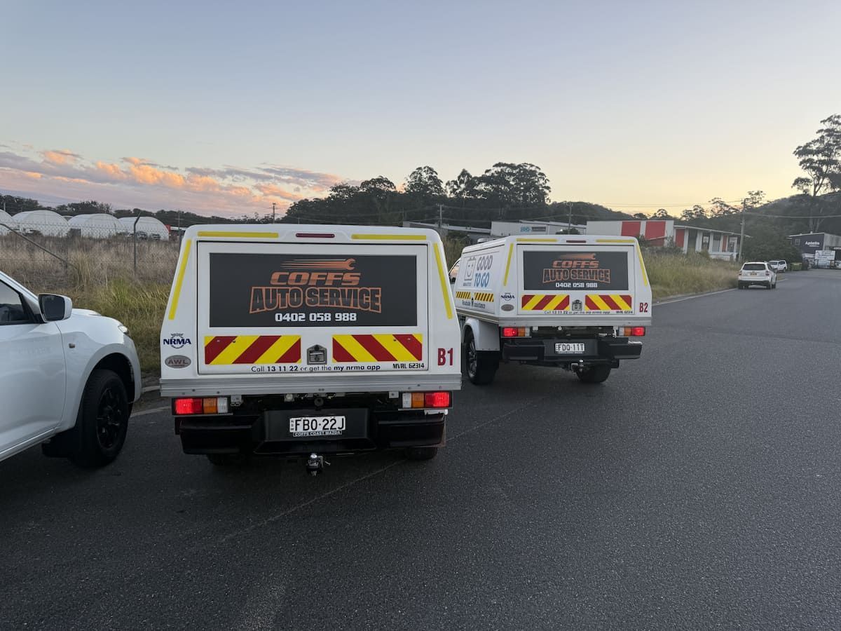 Two White Utility Vans Parked on a Road at Sunset, With a Car at Left and Hills — Coffs Auto Service in North Boambee Valley, NSW