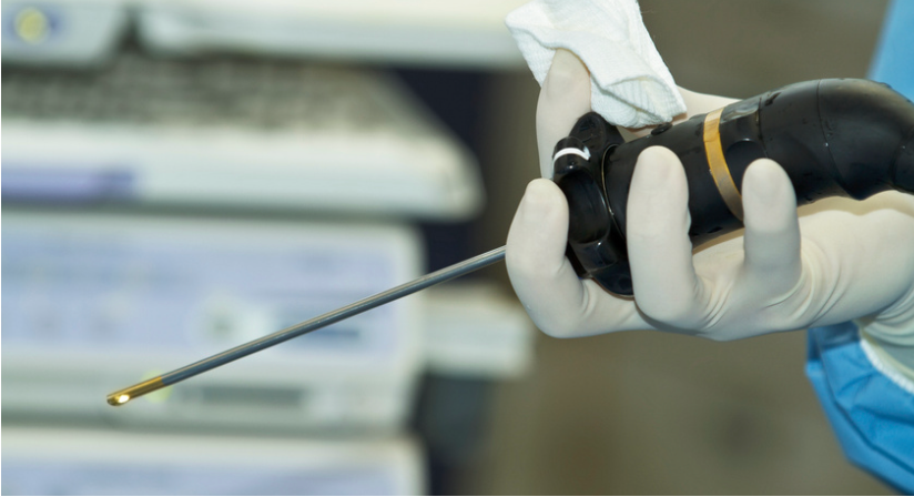 A person wearing gloves is holding a screwdriver in their hand.