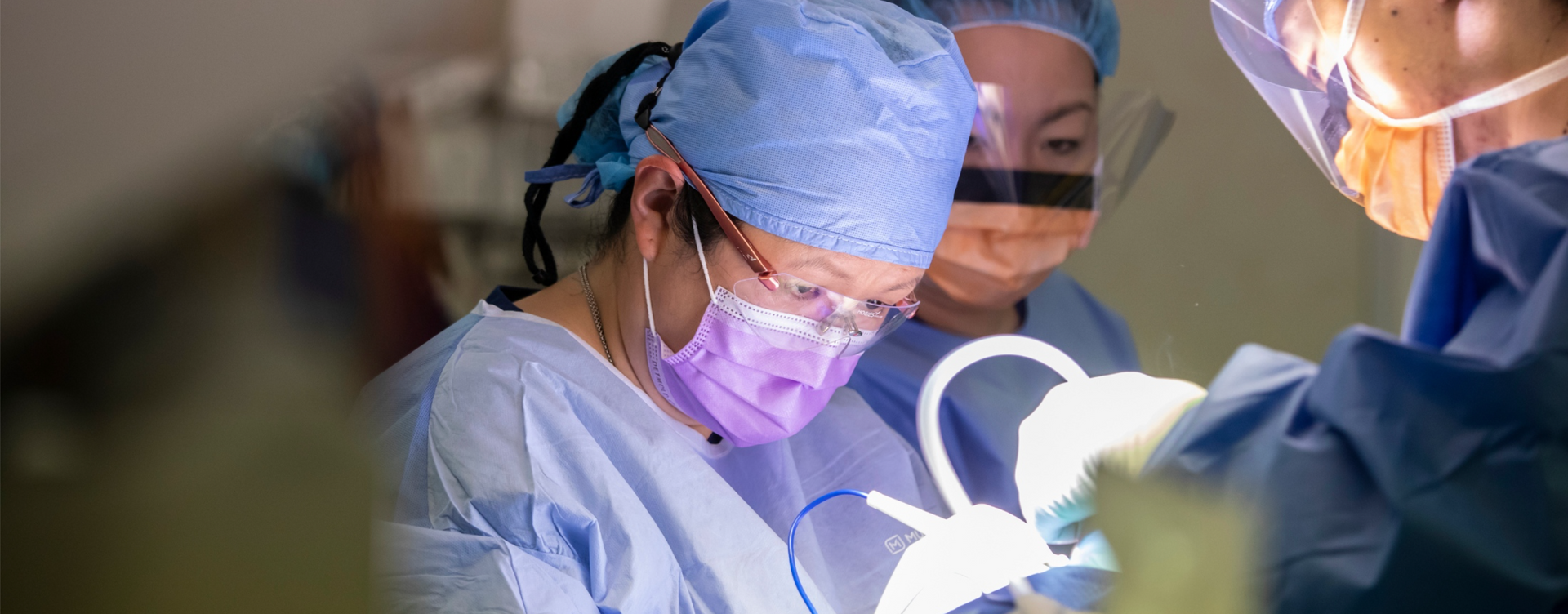 A group of surgeons are operating on a patient in an operating room.