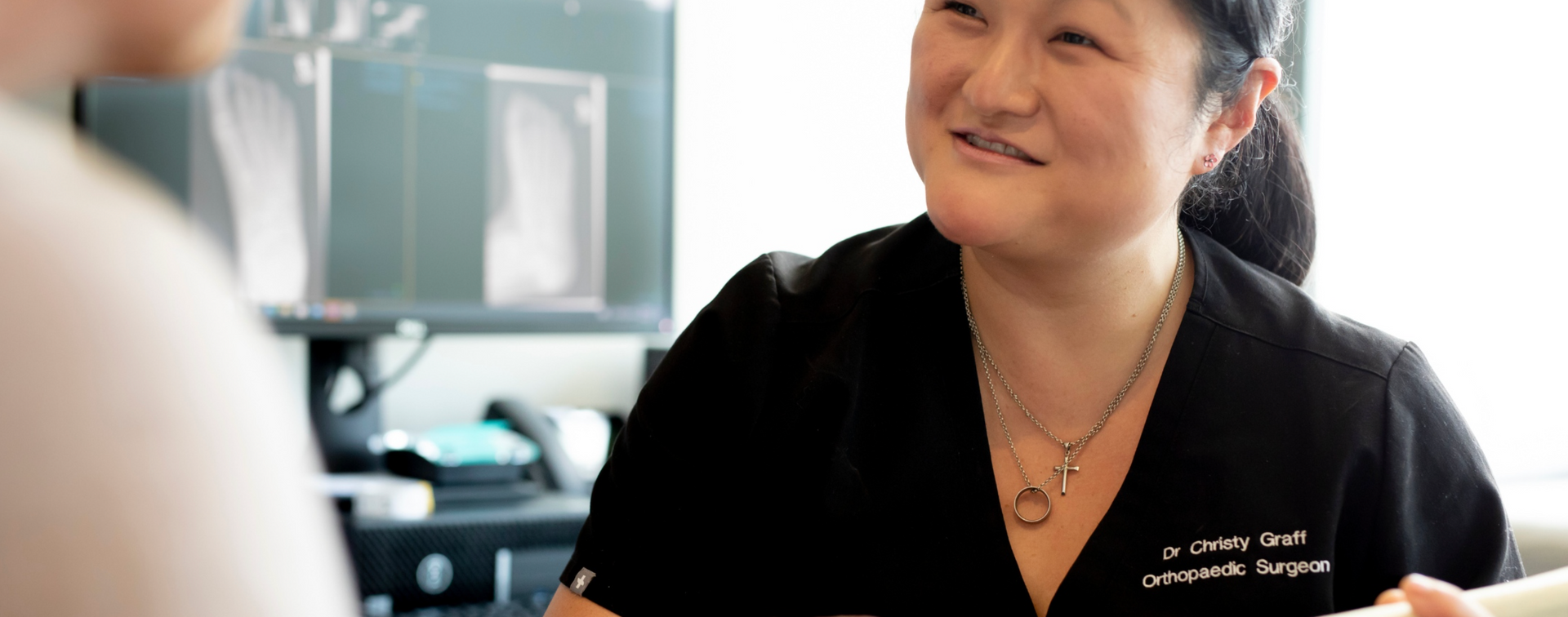 A woman in a black shirt is talking to a man in a room.