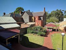 An aerial view of a brick building with a gazebo in the backyard.