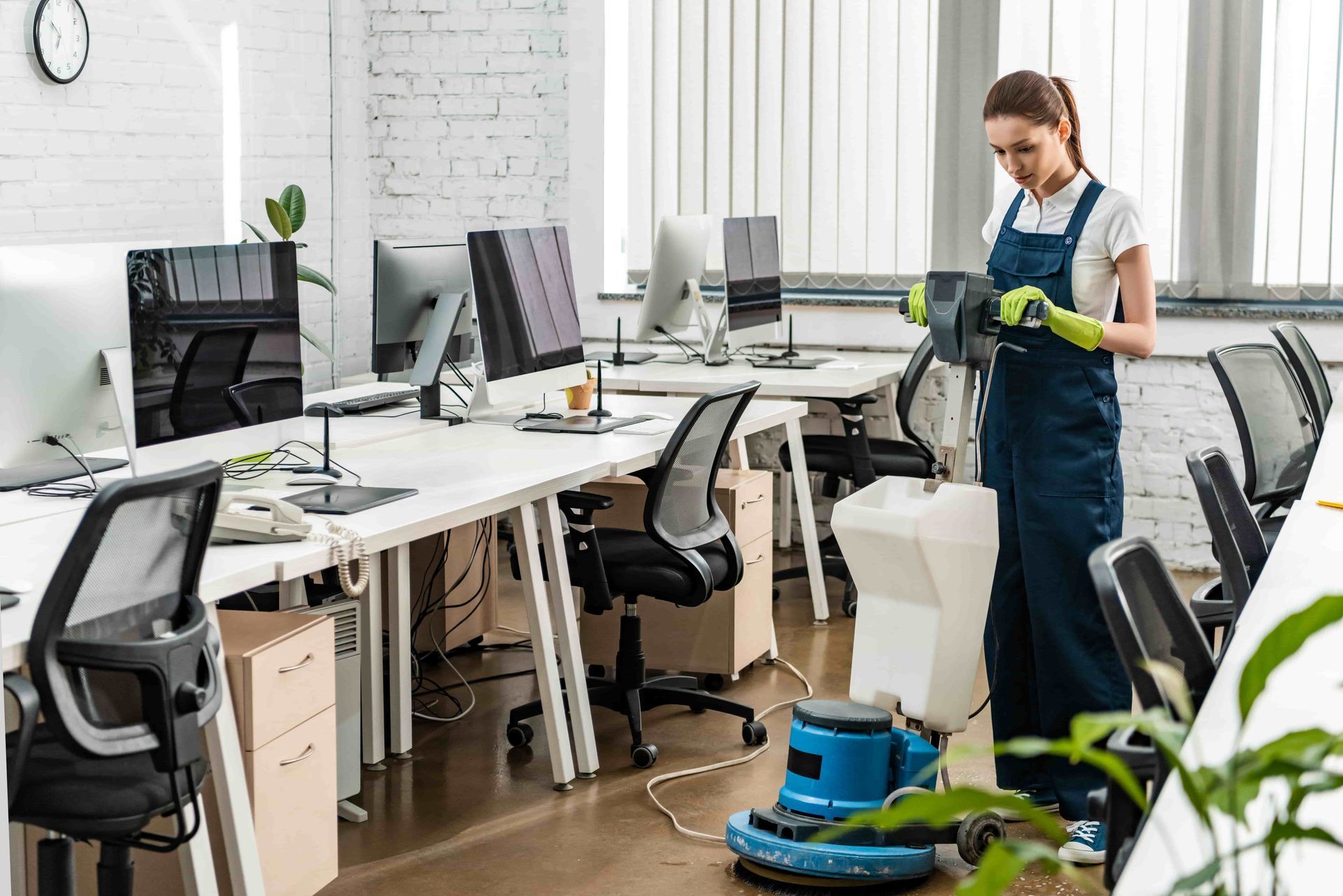 Woman cleaning an office floor with a floor buffer machine.