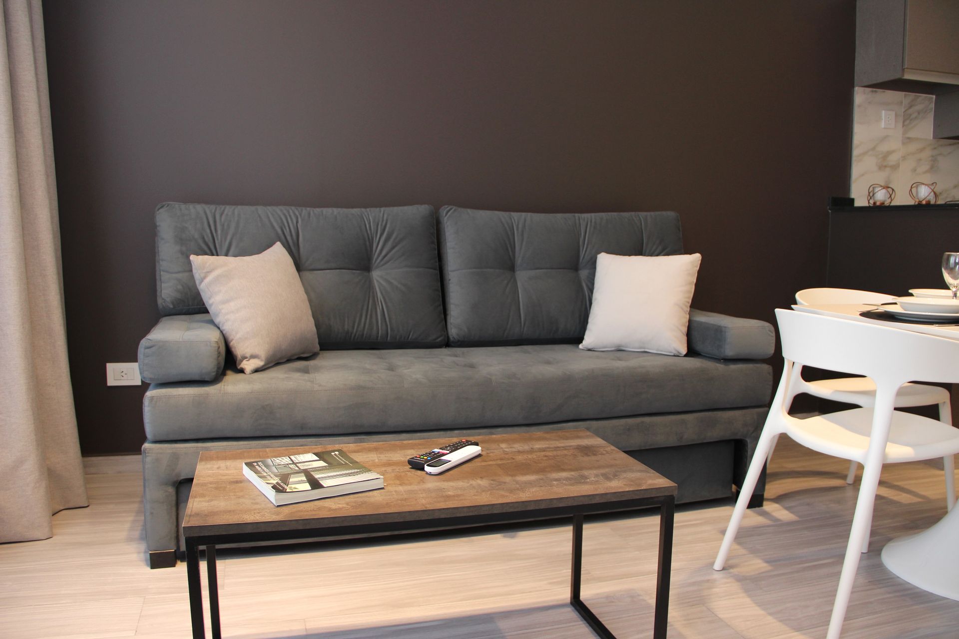 Gray sofa with two pillows behind a wooden coffee table in a modern living room