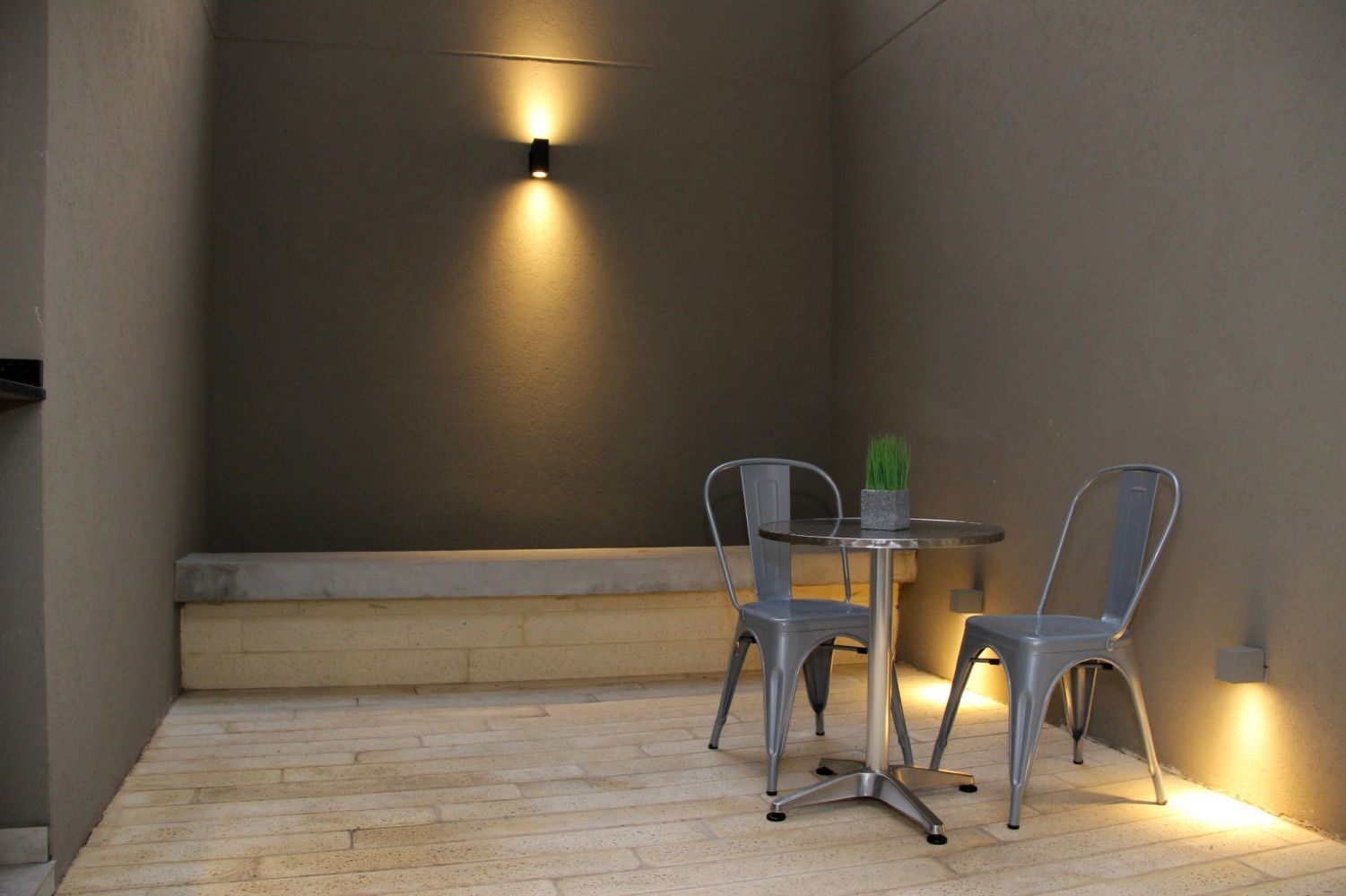 Patio con mesa y sillas iluminado al atardecer, Le Coq