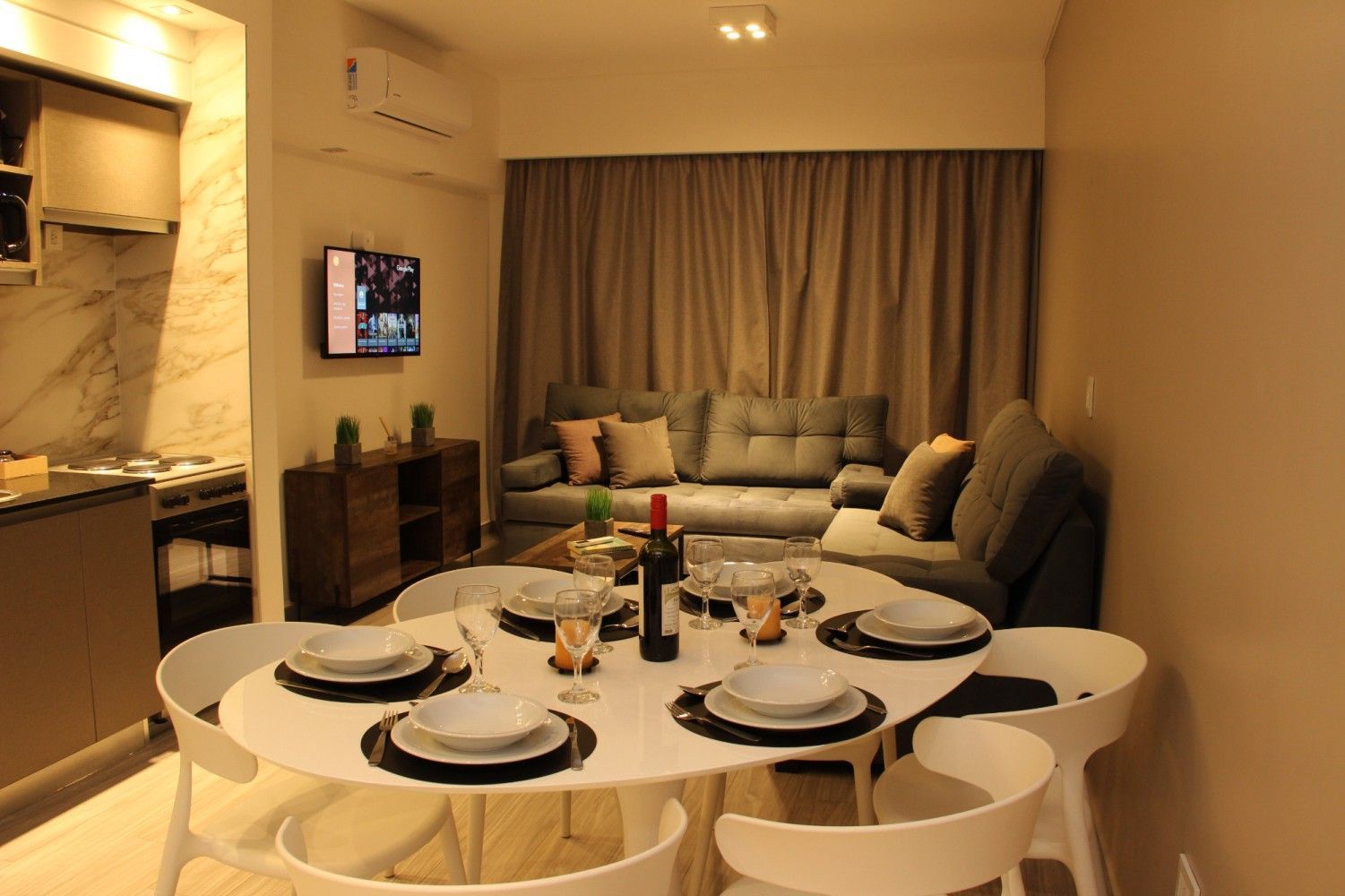 Living comedor con mesa, sillón y televisor, departamento en Le Coq