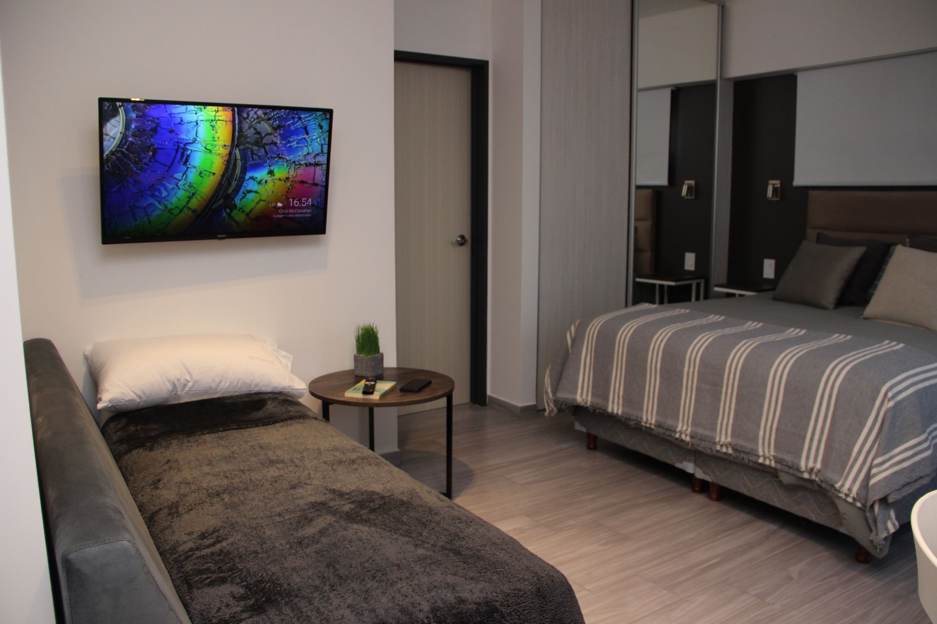 Modern bedroom with two beds, wall art, and neutral gray decor