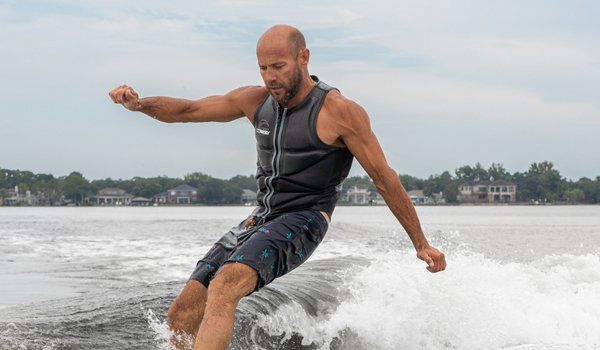 A man doing a wake surf while bend
