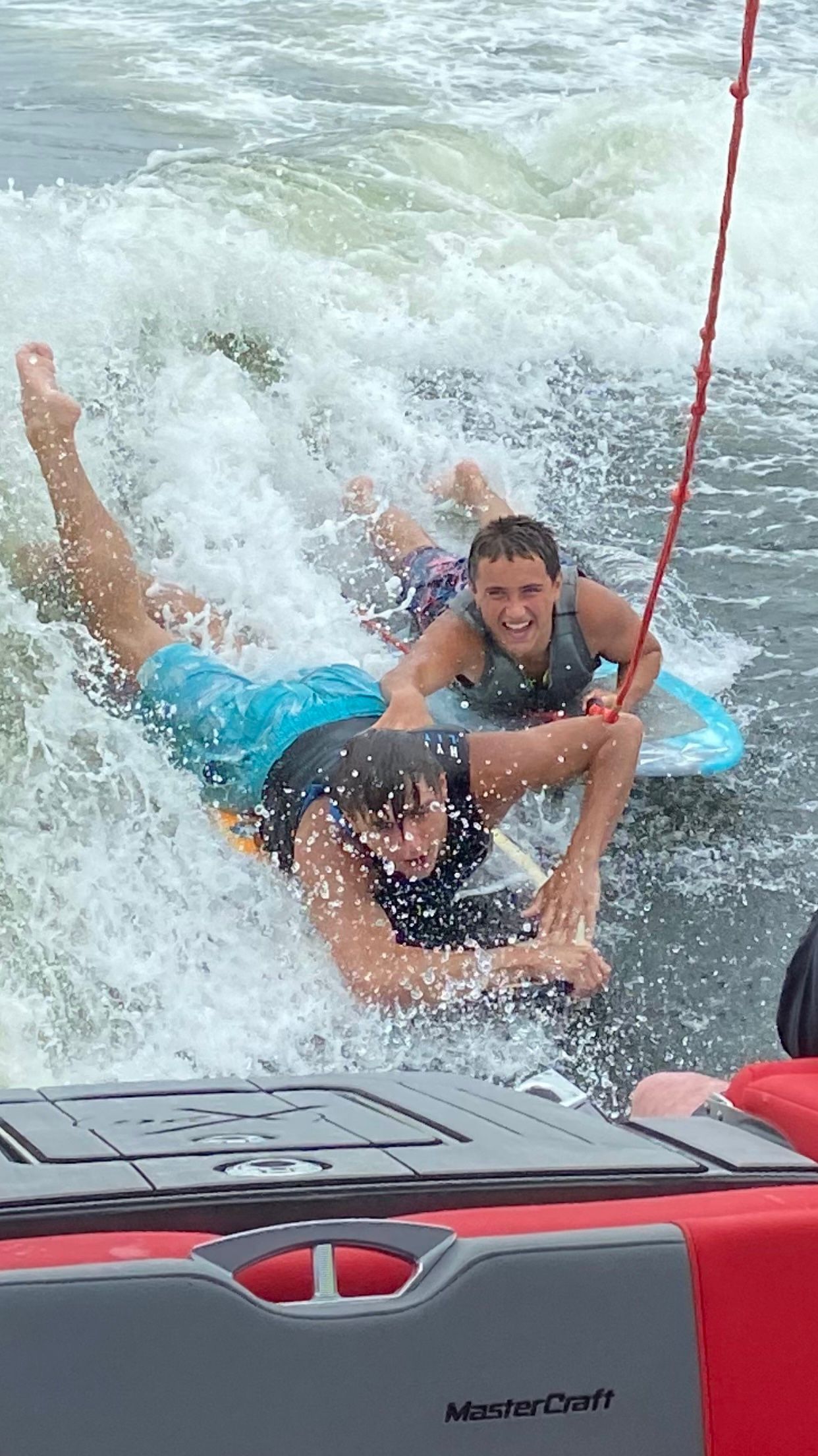 A person is laying on a surfboard in the water.