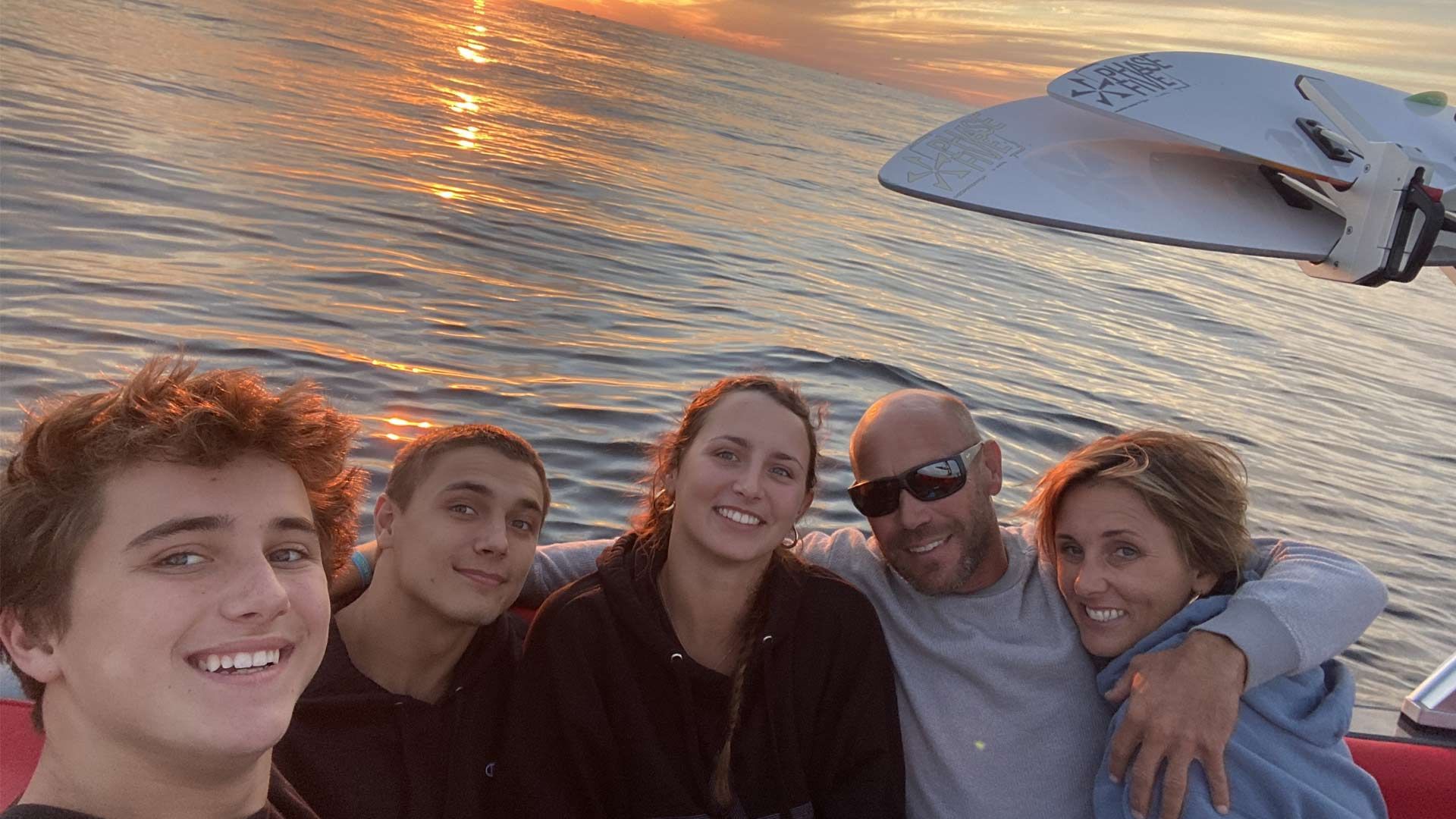 A family is posing for a picture on a boat in the ocean.