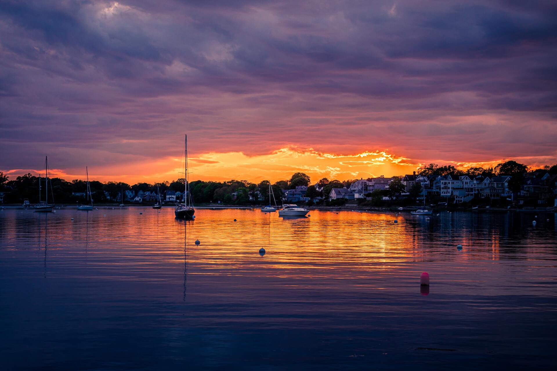 A sunset over a body of water with boats in it.