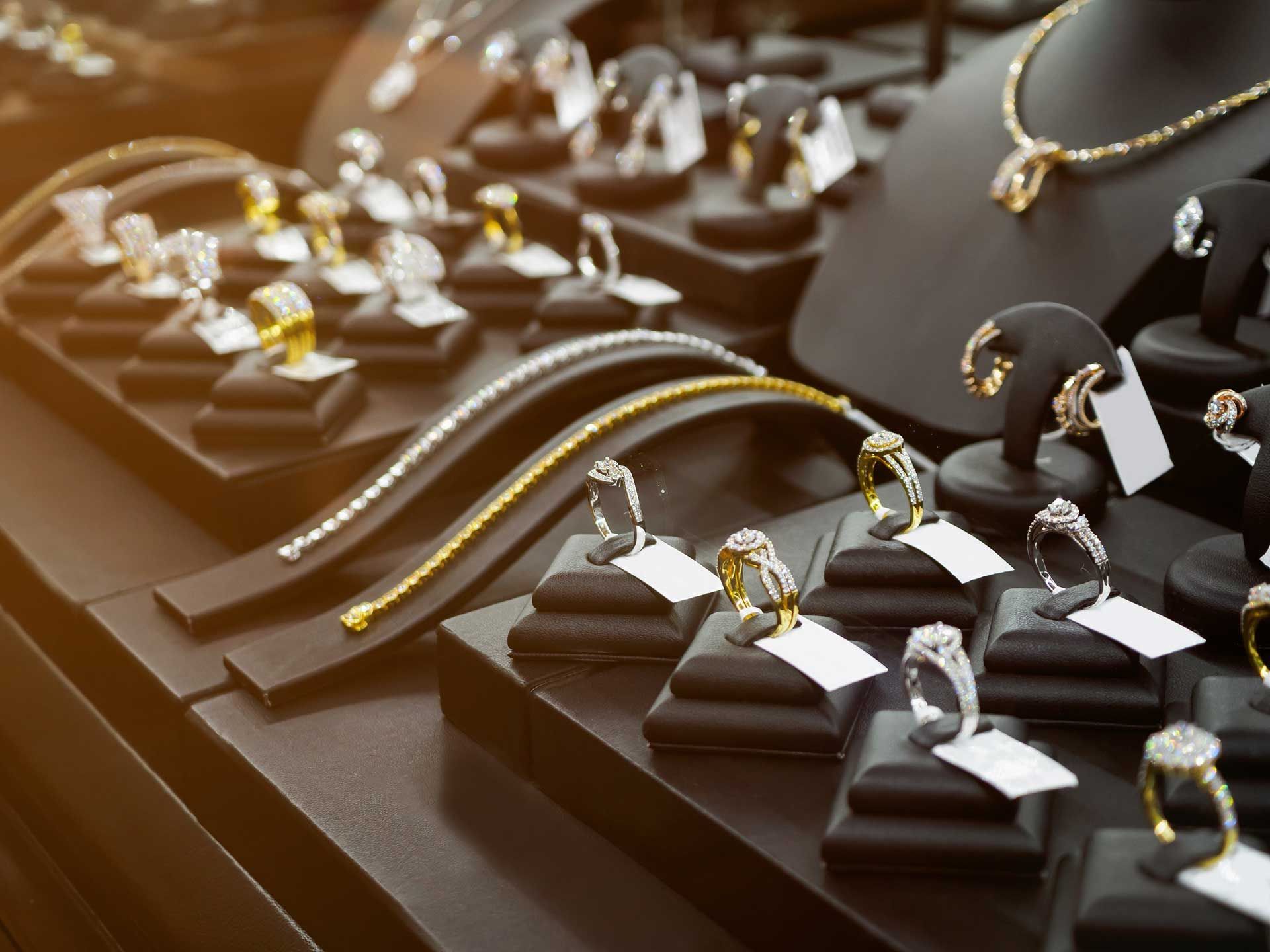 Jewelry display case with rings, bracelets, and necklaces on black stands. Jewelry display case with rings, bracelets, and necklaces on black stands.