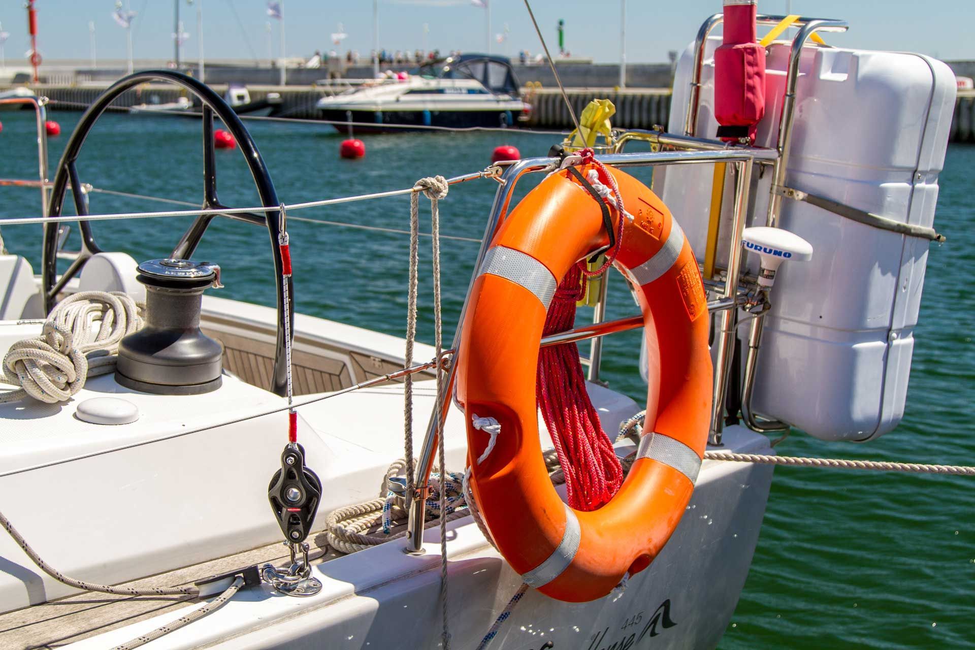 Orange life preserver and safety equipment on a sailboat at a marina. Orange life preserver and safety equipment on a sailboat at a marina.