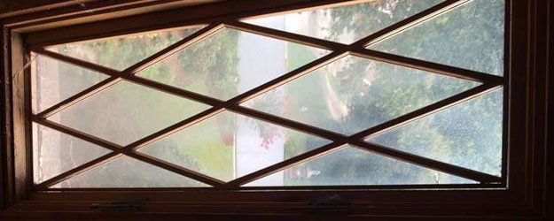 A close up of a stained glass window with a wooden frame.