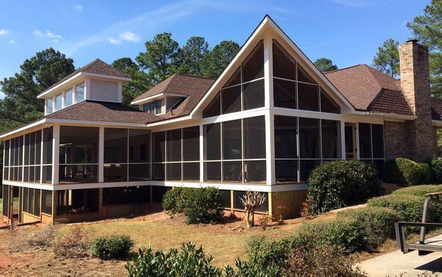 A screened in porch on the side of a brick building - Atlanta, GA - Parker & Son Screen & Glass Inc.