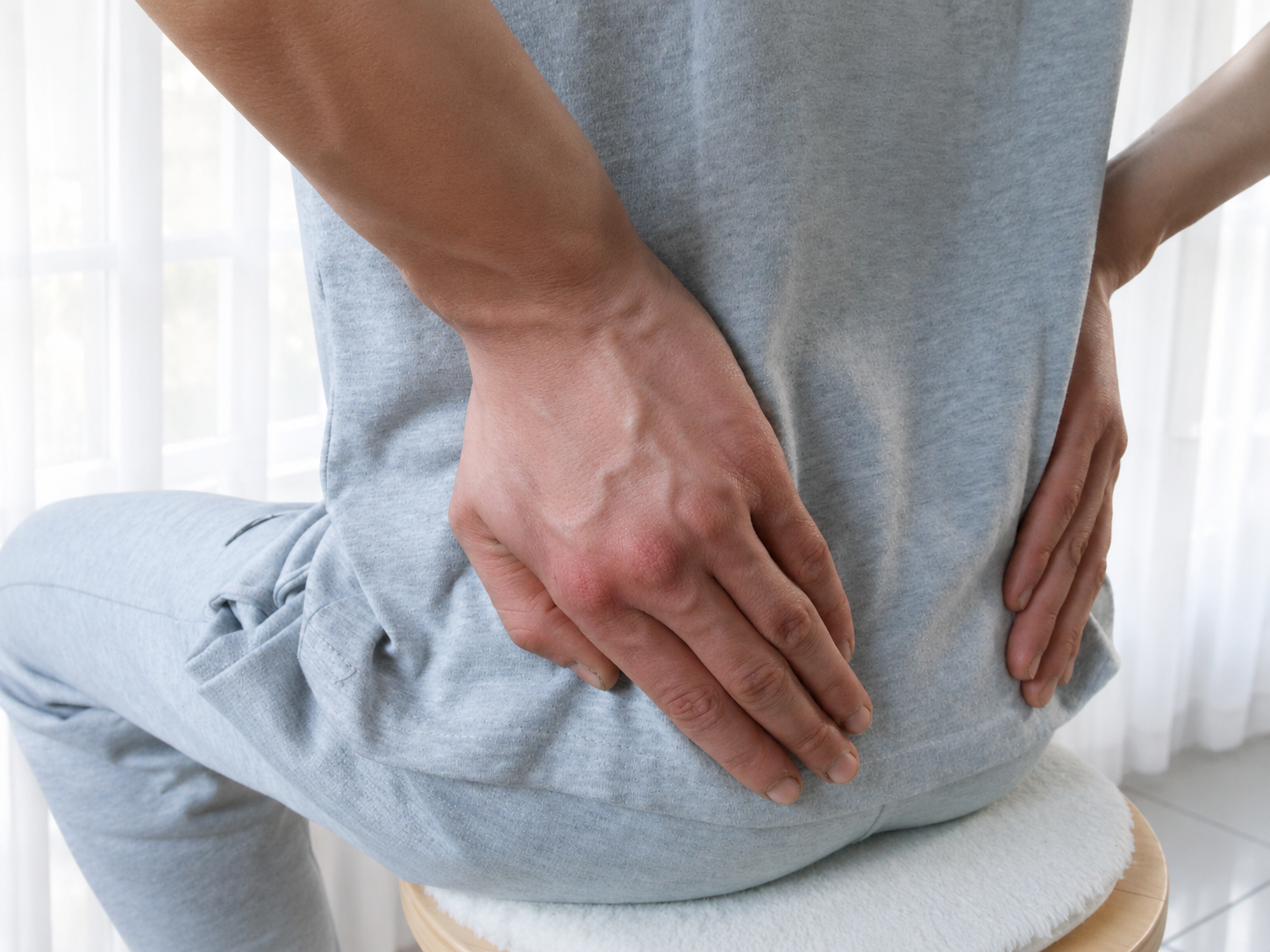 De persoon geeft Reiki aan zijn onderrug.