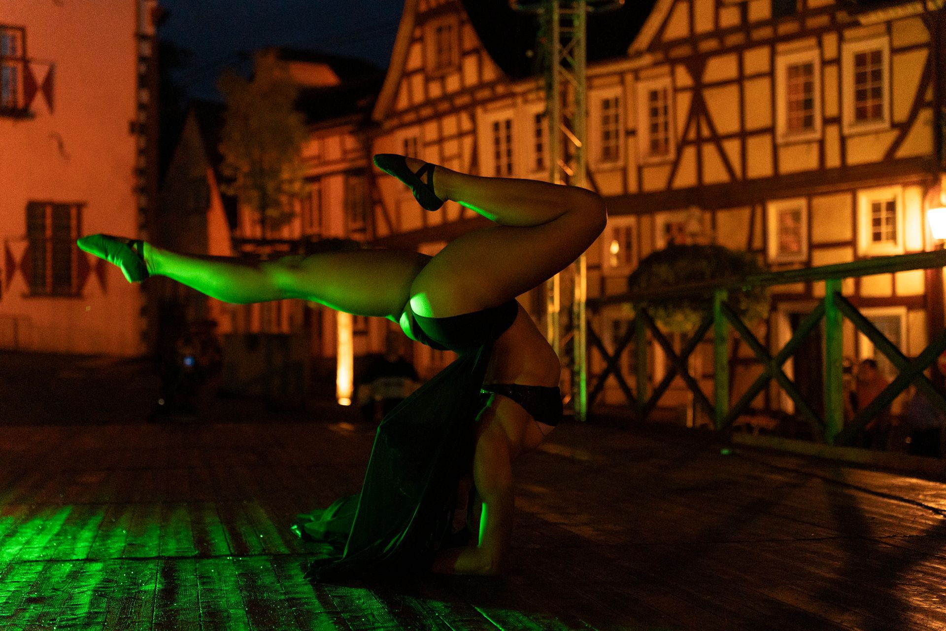 Street performers: stilt walker with butterfly wings, two women in fairy costumes doing cartwheels.