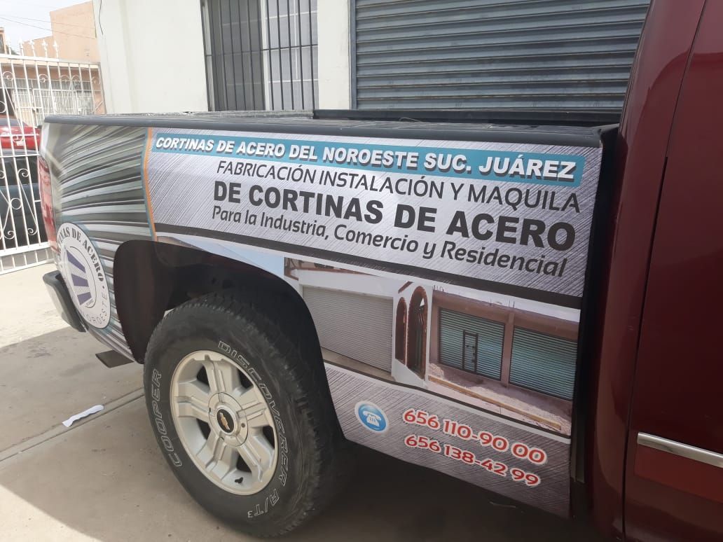 Un camión rojo con un cartel en la parte trasera que dice cortinas de acero.