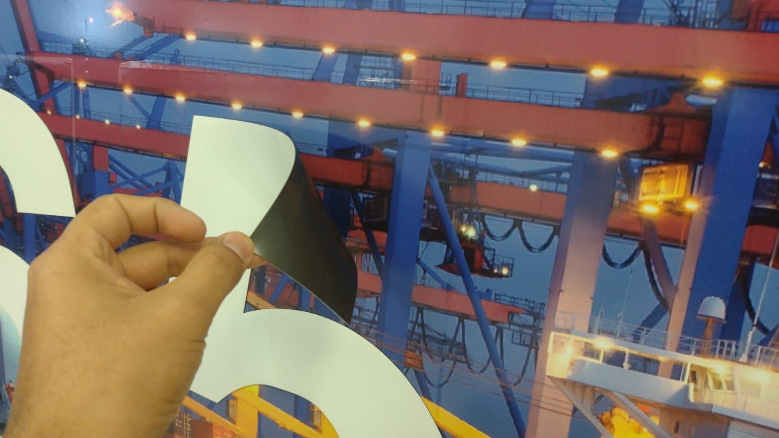 Una persona sostiene un trozo de papel delante de una imagen de un edificio.