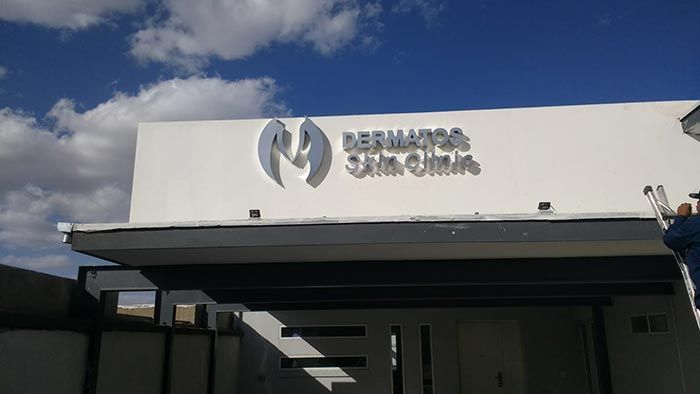Un hombre está parado en una escalera frente a un edificio que dice Bernardo.