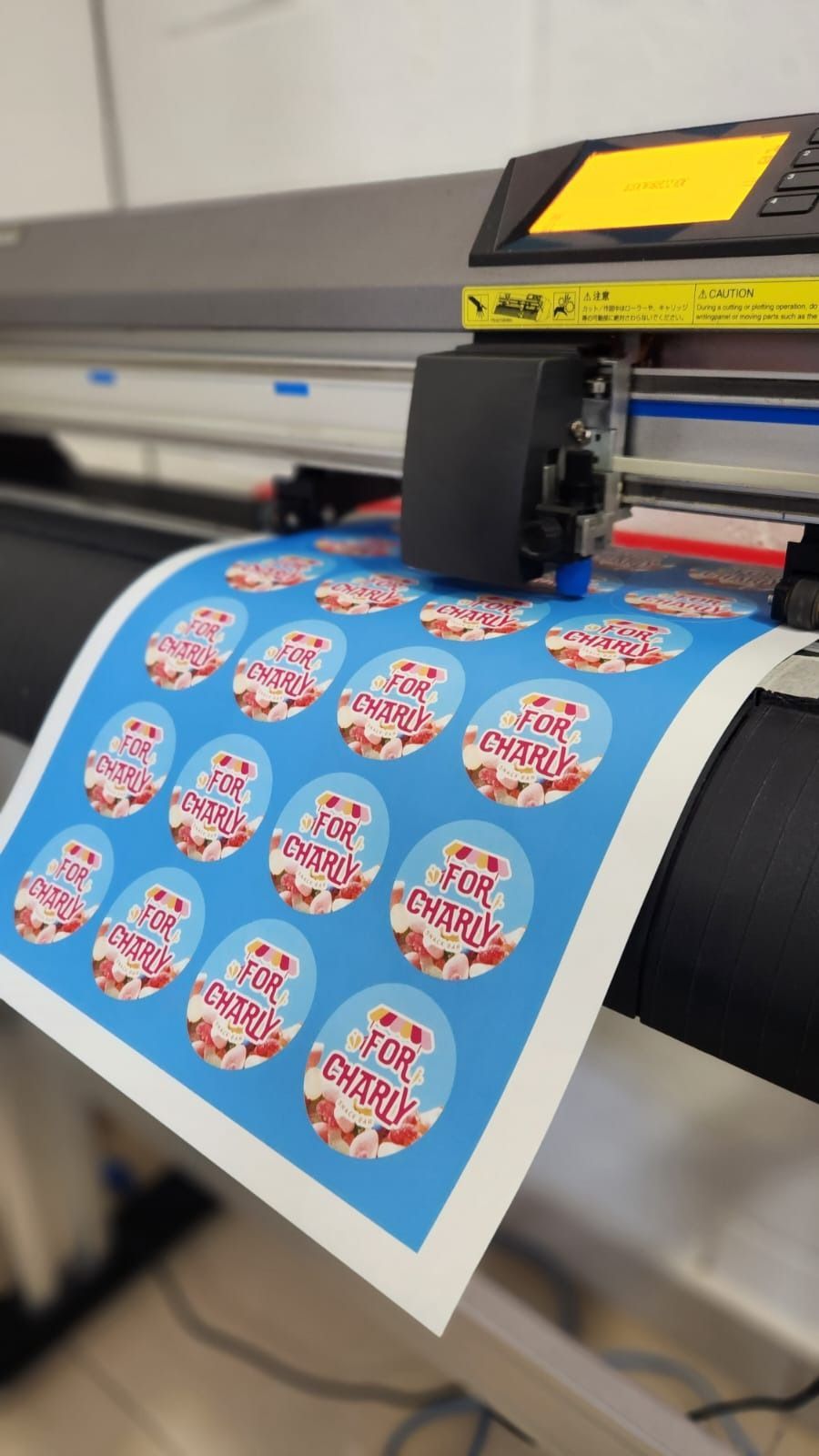 Una máquina está imprimiendo pegatinas en un trozo de papel.