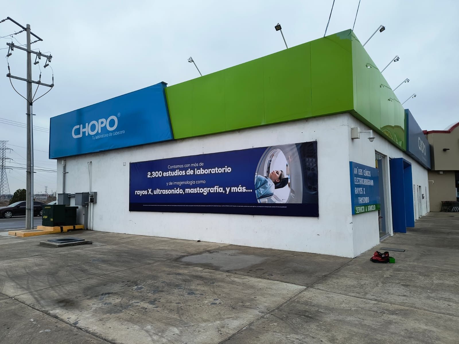 Una tienda de chopos con un cartel azul y verde en el costado.