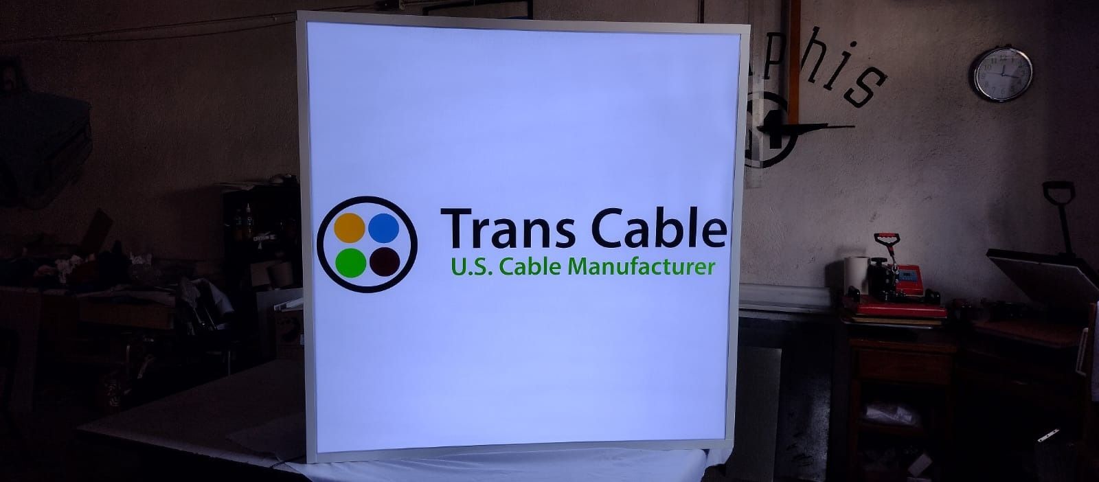 Un cartel con un cable trans está sobre una mesa en un garaje.