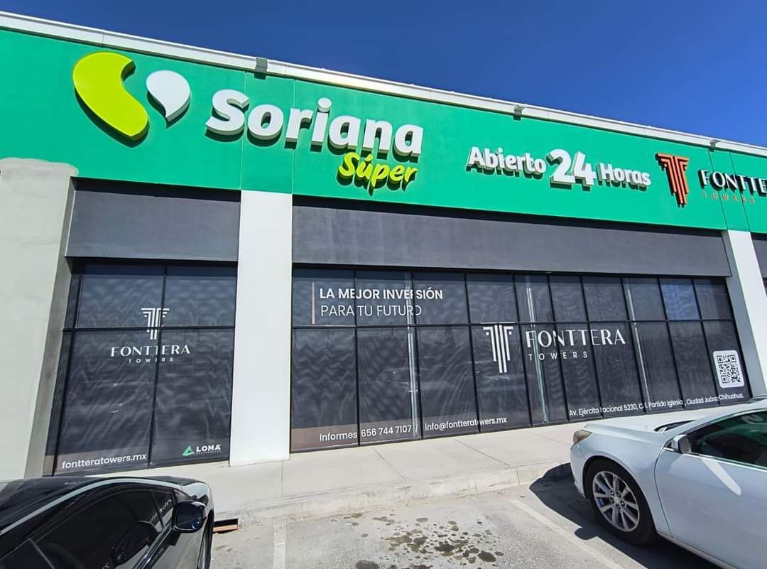 Un coche blanco está estacionado frente a una tienda Soriana Super.