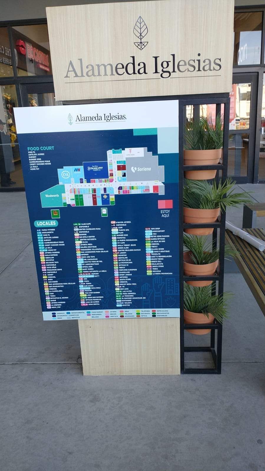 Un mapa de un edificio con plantas en macetas delante de él.
