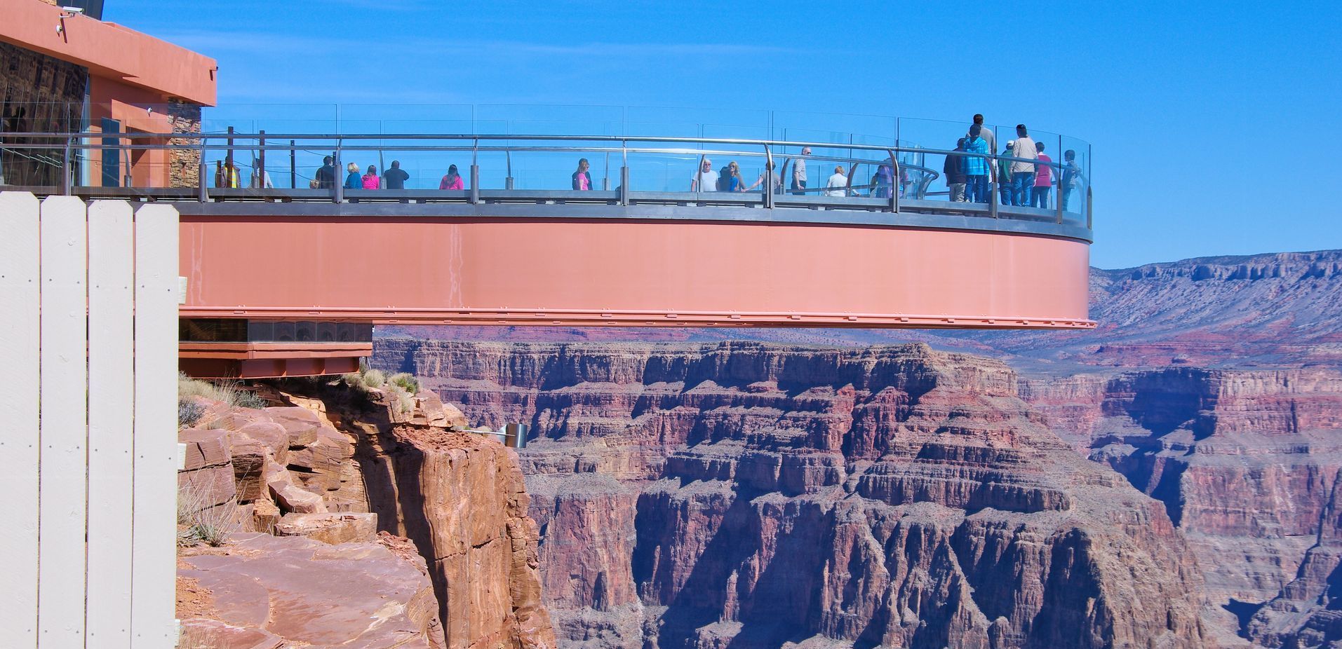 A group of people are standing on a bridge over a canyon.