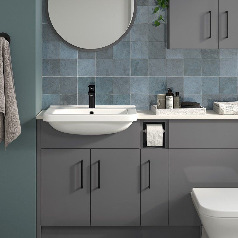 Bathroom vanity with gray cabinets, white sink, black faucet, and blue tiled backsplash.