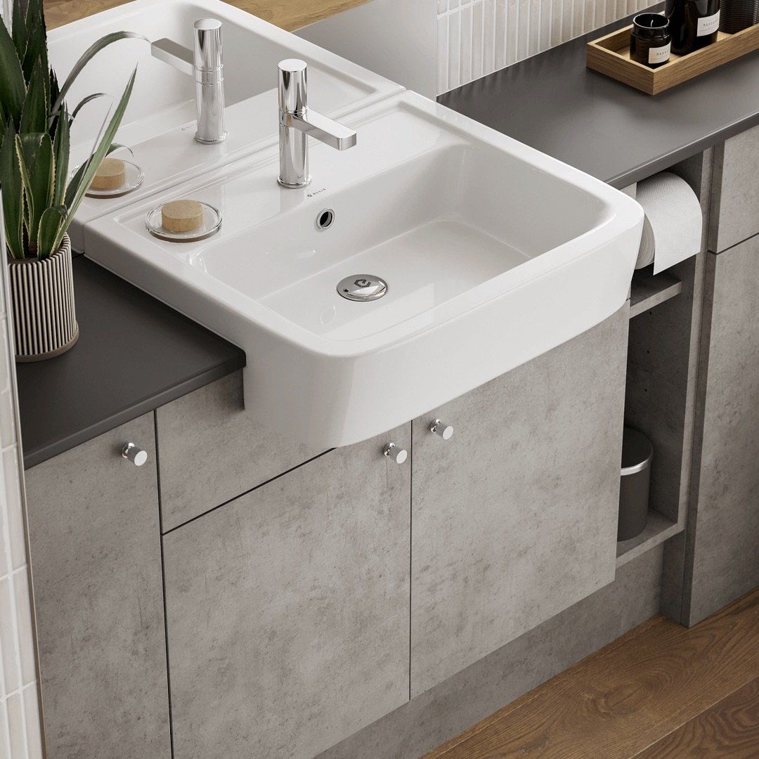 White sink with chrome faucets, mounted on gray cabinets.