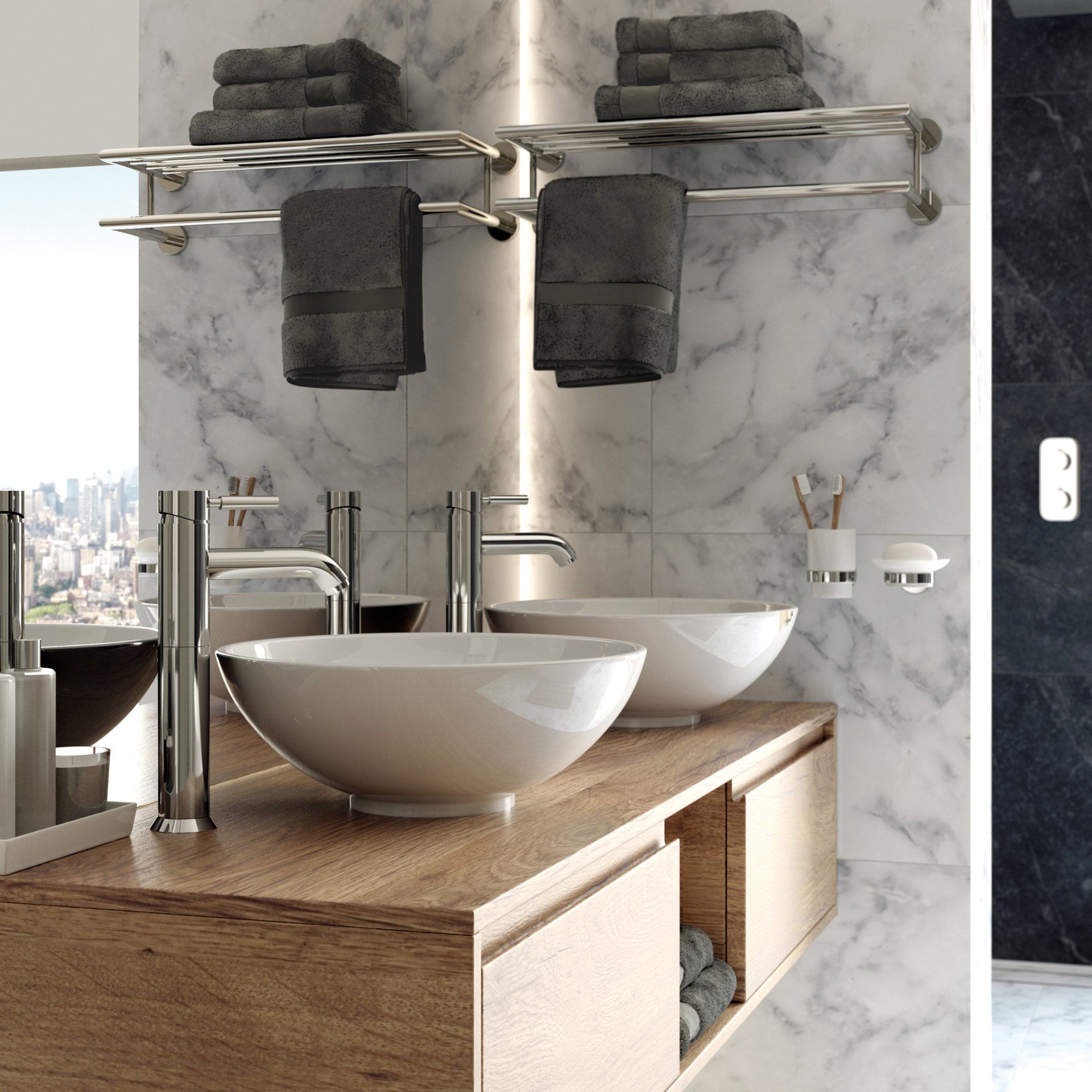 Bathroom with marble walls, wood vanity, two vessel sinks, and towel racks with gray towels.