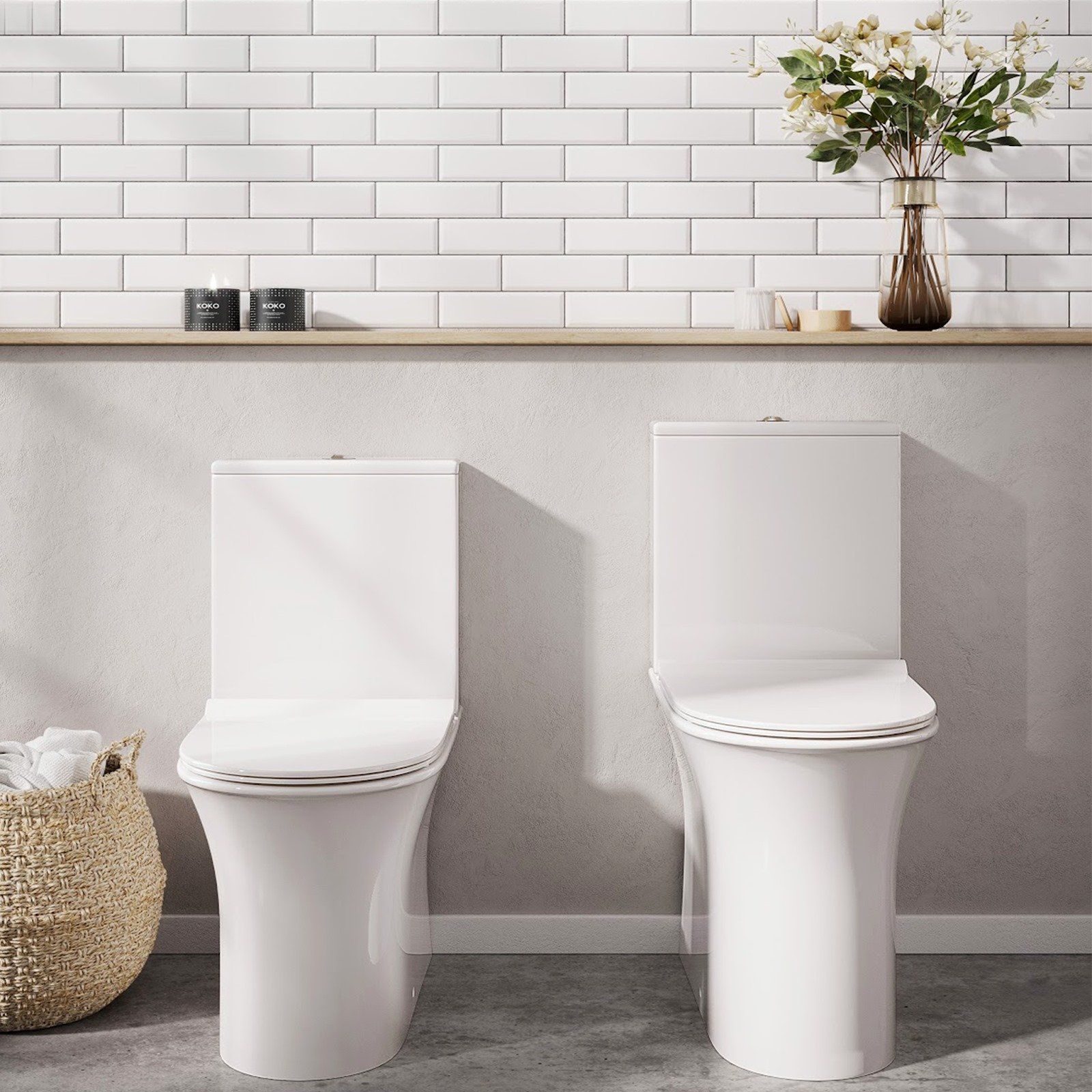 Two white, modern toilets in a bathroom setting, against a white brick wall and shelf.