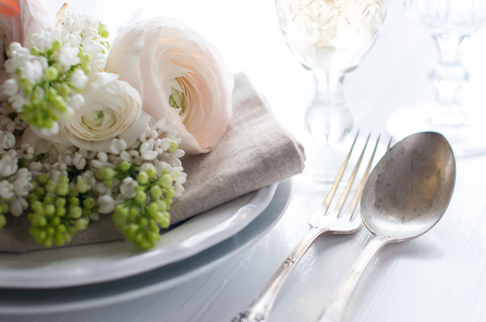 A plate with flowers on it and silverware on a table.