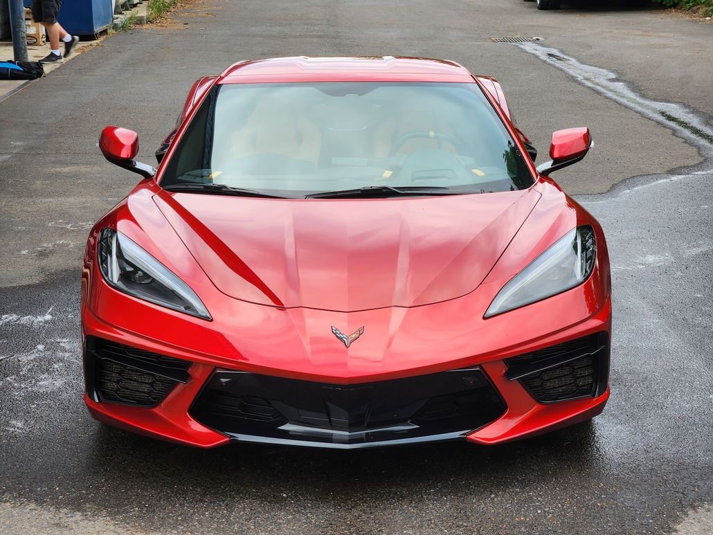 A red sports car is parked on the side of the road