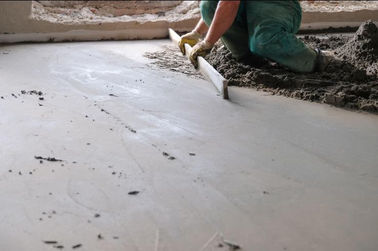 “Close-up of a worker leveling a fresh concrete surface for a smooth finished slab by a concrete contractor in Oro Valley, AZ”