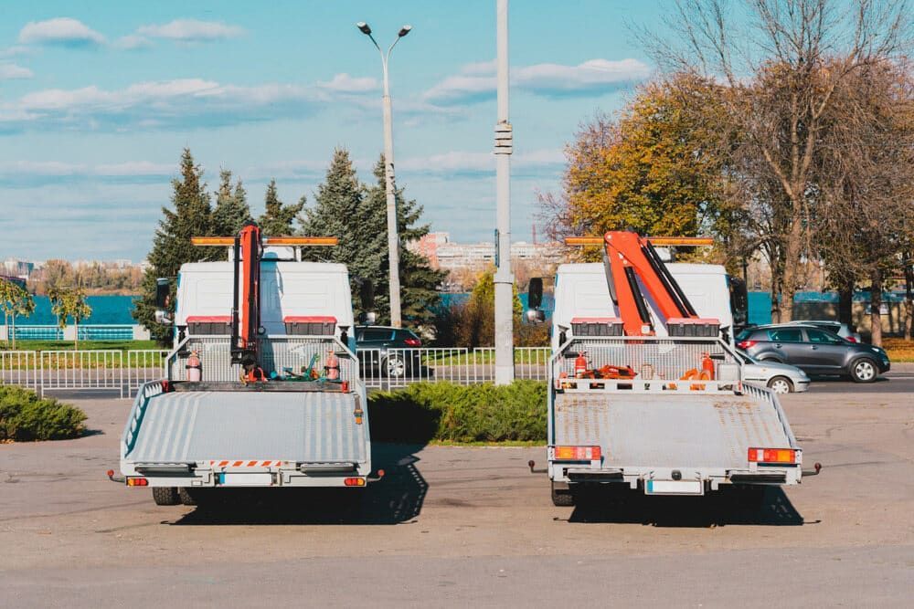 Two Tow Trucks Are Parked Next To Each Other In A Parking Lot — Ollies Towing & Shipping Container Sales in Blackbutt, QLD