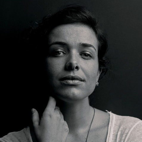 Uma mulher está tocando o rosto em uma foto em preto e branco.