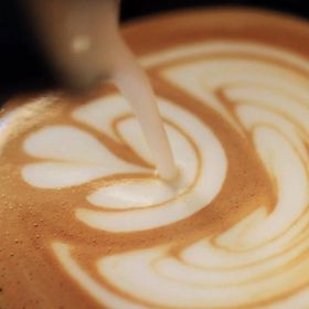 Un primo piano di una tazza di caffè con il latte versato dentro.