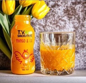 Una bottiglia di frullato tv mango e compagnia accanto a un bicchiere