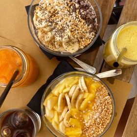 Tre ciotole di cibo su un tavolo, tra cui banane e ananas